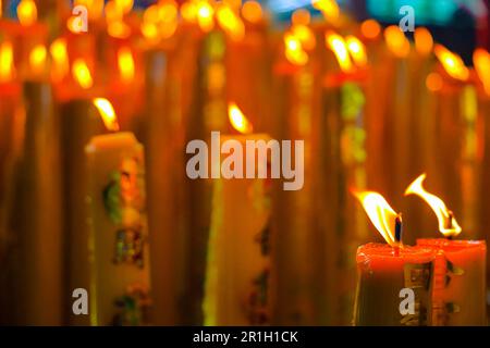 Gelbe Wachskerzen chinesische Kerzen mit Glückssymbol, die rote chinesische Kerze in einem chinesischen Tempel oder Schrein brennen. Schreiben Sie auf Chinesisch, um Glück und Glückssymbol zu bedeuten. Stockfoto