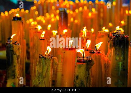 Gelbe Wachskerzen chinesische Kerzen mit Glückssymbol, die rote chinesische Kerze in einem chinesischen Tempel oder Schrein brennen. Schreiben Sie auf Chinesisch, um Glück und Glückssymbol zu bedeuten. Stockfoto