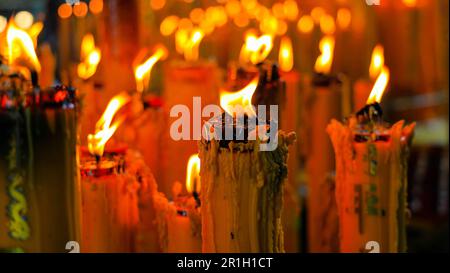 Gelbe Wachskerzen chinesische Kerzen mit Glückssymbol, die rote chinesische Kerze in einem chinesischen Tempel oder Schrein brennen. Schreiben Sie auf Chinesisch, um Glück und Glückssymbol zu bedeuten. Stockfoto