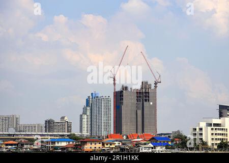 Turmkräne auf der Gebäudeoberseite, die auf der Baustelle verwendet werden. Stockfoto