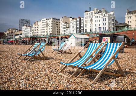 Leere Liegestühle, die paarweise am Kieselstrand in Brighton in East Sussex, Großbritannien, aufgestellt wurden. Brighton, eine lebendige und pulsierende Stadt, ist ein beliebtes Reiseziel Stockfoto