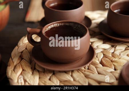 Teezeremonie. Traditionelles Asiatisches Teeutensil, Serviert Authentisches Set. Person, die Tee von der Teekanne aus brauner Keramik bis zur Teekanne einschenkt. Bambusschale. Lifestyle. Wir Stockfoto