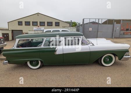 Rayleigh, Großbritannien. Mai 2023. Ein gut erhaltener grün-weißer Kombi aus der Mitte des 20. Jahrhunderts mit Weißwandreifen und Chromdetails, parkt vor einem Wellblech-Geschäftsgebäude in Rayleigh, Essex. Der Kontrast zwischen dem Oldtimer und der zweckmäßigen Umgebung weckt Nostalgie und industrielles Erbe. Farm Fresh Garage Truck und amerikanische Fahrzeuge werden gezeigt. Penelope Barritt/Alamy Live News Stockfoto