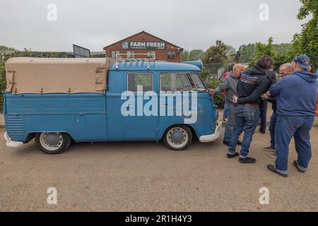 Rayleigh, Großbritannien. Mai 2023. Ein klassischer blauer Volkswagen Type 2 Pickup Truck mit Leinwandabdeckung steht neben einem Backsteingebäude mit der Aufschrift „Farm Fresh“ in Rayleigh, Essex. Die Einheimischen versammeln sich um das Fahrzeug und erwecken ein Gefühl von Gemeinschaft und Nostalgie. Farm Fresh Garage Truck und amerikanische Fahrzeuge werden gezeigt. Penelope Barritt/Alamy Live News Stockfoto