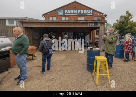 Rayleigh, Großbritannien. Mai 2023. Die Einheimischen treffen sich außerhalb der Farm Fresh in Rayleigh zu einem Gemeinschaftsevent mit Live-Musik, Imbissständen und geselligem Beisammensein. Eine kleine Band spielt unter der Markise, während Besucher gegrillte Speisen und Getränke an den Tischen genießen. Farm Fresh Garage Truck und amerikanische Fahrzeuge werden gezeigt. Penelope Barritt/Alamy Live News Stockfoto