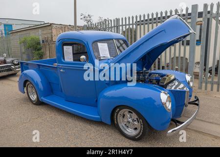 Rayleigh, Großbritannien. Mai 2023. Ein restaurierter blauer Pickup-Truck aus den 1940er Jahren mit offener Motorhaube und poliertem Motor wird auf einer Oldtimerausstellung in Rayleigh, Essex, gezeigt. Informationsblätter auf der Windschutzscheibe weisen auf historische und mechanische Details hin. Andere klassische Fahrzeuge und ein Industriebau bilden die Kulisse. Farm Fresh Garage Truck und amerikanische Fahrzeuge werden gezeigt. Penelope Barritt/Alamy Live News Stockfoto
