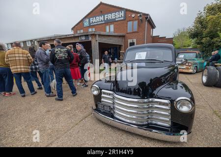 Rayleigh, Großbritannien. Mai 2023. Die Fans treffen sich vor der Farm Fresh Garage in Rayleigh, Essex, für ein Oldtimer-Treffen mit Oldtimern, Retro-Mode und geselligen Gesprächen. Ein glänzender schwarzer Truck ist sichtbar, der an Stil und Rockabilly-Kultur der Mitte des Jahrhunderts erinnert. Farm Fresh Garage Truck und amerikanische Fahrzeuge werden gezeigt. Penelope Barritt/Alamy Live News Stockfoto