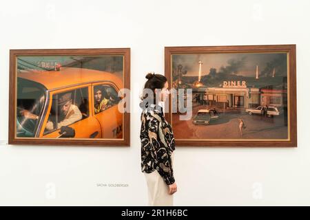 London UK. 14. Mai 2023 Ein Galeriemitglied mit Werken von Sacha Goldberger, L-R-Objekte in einem Spiegel sind näher als sie scheinen 2021, Invasion Day, Dawn, 2021, Galerie XII, Los Angeles. Die 8. Ausgabe von Photo London im Somerset House London zeigt 126 führende internationale Galerien und Verleger, die Werke von Fotografen mit kuratierten Ausstellungen und Vorträgen zeigen und verkaufen. Foto: London ab 11-14. Mai. Kredit: amer Ghazzal/Alamy Live News Stockfoto