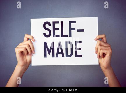 Und stolz darauf. Eine nicht identifizierbare junge Frau, die ein Poster mit einer Nachricht im Studio hält. Stockfoto