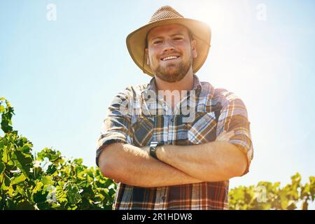 Das Leben auf der Farm ist besser. Ein Bauer mittleren Alters, der auf einem Weinberg posiert. Stockfoto