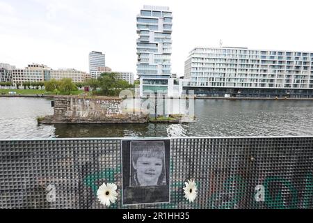 Berlin, Deutschland. 14. Mai 2023. Die Berliner Mauerstiftung gedenkt Siegfried Kroboth, Der im Alter von fünf Jahren am 14. Mai 1973 an dieser Sektorgrenze zwischen Ost- und Westberlin in die Spree fiel, mit einer öffentlichen Gedenkfeier am Unfallort in der Nähe der East Side Gallery. Die Westberliner Task Forces, die sofort alarmiert wurden, waren nicht autorisiert, an der Wassergrenze einzugreifen. Die Grenzschutzbeamten der DDR aus Ostberlin reagierten anfangs nicht. Kredit: Joerg Carstensen/dpa/Alamy Live News Stockfoto