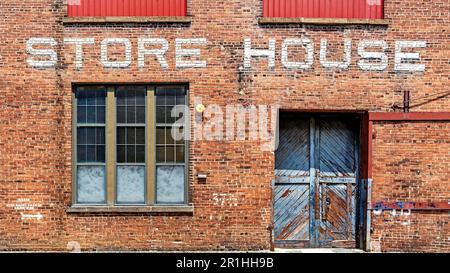 Backsteinhintergrund des Lagerhauses mit über der Tür angebrachtem Store House Stockfoto
