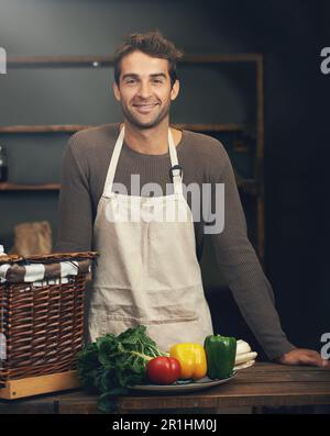 Koch, Lächeln und Porträt eines Mannes in der Küche mit Gemüse für vegetarische Mahlzeit, gesunde Ernährung oder vegane Ernährung. Kochen, Glück und selbstbewusster Mann Stockfoto