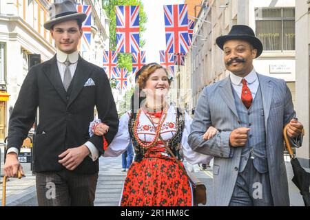 London, Großbritannien. 14. Mai 2023. Zwei Männer gehen mit einer jungen Dame in polnischen Folklorekleidern entlang der Jermyn Street. Auf dem jährlichen Grand Flaneur Walk sehen Sie Kerle und Kapseln, Dandys und Quaintrelle in makelloser Schneiderei und stilvoller Flanning und unnötiges Herumsäen rund um St James' und die umliegenden Gegenden von London. Der Spaziergang beginnt immer an der Statue des geselligen Dandy Beau Brummell und führt langsam durch die Gegend. Kredit: Imageplotter/Alamy Live News Stockfoto