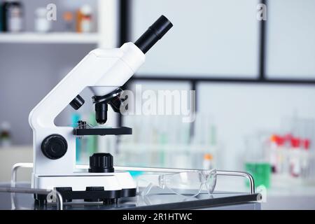 Modernes medizinisches Mikroskop auf Metalltisch im Labor, Platz für Text Stockfoto