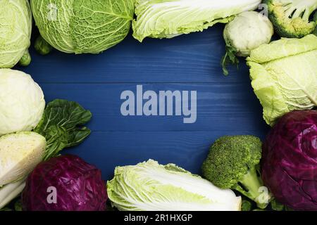 Rahmen aus verschiedenen Kohlen auf blauem Holztisch, flach liegend. Platz für Text Stockfoto