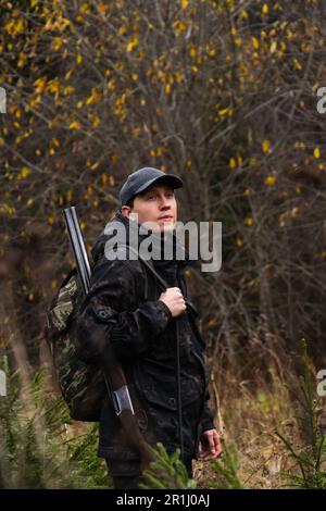 Jäger mit einer Waffe und einem Rucksack im Wald. Hochwertiges Foto Stockfoto