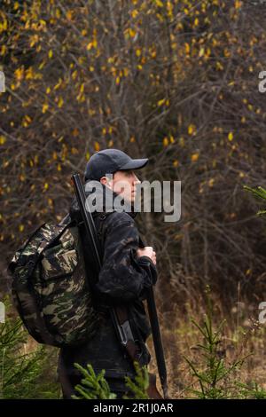 Jäger mit einer Waffe und einem Rucksack im Wald. Hochwertiges Foto Stockfoto