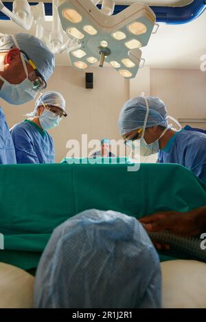 Unter das Messer gehen. Ein Team von Chirurgen, die eine Operation in einem Operationssaal durchführen. Stockfoto