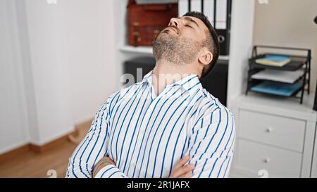 Junger hispanischer Geschäftsmann schläft im Büro Stockfoto