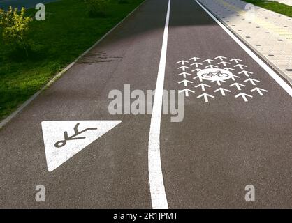 Fahrrad- und Fußgängerschilder, bemalte Straßenmarkierungen, Fahrspur. Stockfoto