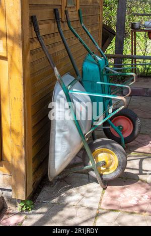 Garten leere Wagen an der Wand des Cottages. Garten, ländlich, Hütte. Stockfoto