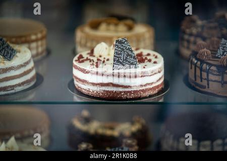 Eine Auswahl an frisch gebackenen Kuchen, darunter ein roter Samtkuchen und Vanillekuchen Stockfoto