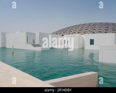 Abu Dhabi, VAE - 21. März 2023 : Außenansicht des berühmten Museums Louvre Abu Dhabi. Schlichte weiße Wände, die einen smaragdgrünen Graben umgeben, der von einem Ornat gekrönt ist Stockfoto