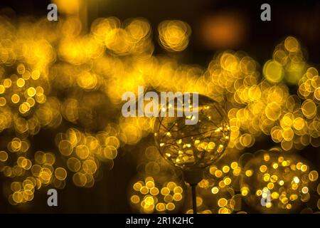 Goldene Bokeh Lichter Hintergrund mit glühender Feenlicht Glasbirne Stockfoto