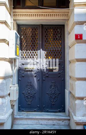 Tür aus schwarzem Metall und Schmiedeeisen mit weißer Front. Design- und Baukonzept. Stockfoto