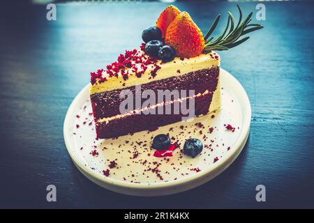 Ein Stück köstlicher roter Samtkuchen auf weißem Teller aus der Nähe Stockfoto