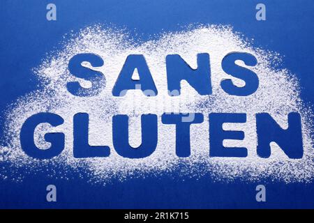 Phrase Gluten Free in französischer Schrift mit Mehl auf blauem Hintergrund, Draufsicht Stockfoto