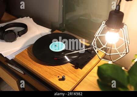 Eleganter Plattenspieler mit Schallplatte auf dem Tisch im Innenbereich Stockfoto