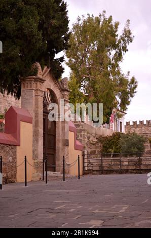 Eingangstür mit Steinsäulen und einem Portiko über der Tür. Hinter der Tür befindet sich der Innenhof der moslemischen Suleiman-Moschee in Rhodos Stockfoto