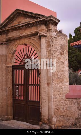 Eingangstür mit Steinsäulen und einem Portiko über der Tür. Hinter der Tür befindet sich der Innenhof der moslemischen Suleiman-Moschee in Rhodos Stockfoto