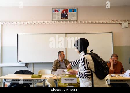 Istanbul, Türkei. 14. Mai 2023. Eine junge Frau, die ihre Stimme in der Saffet Cebi Schule ausgibt, wird mit Kemal Atatürk Porträt im Hintergrund gesehen. 64 Millionen türkische Bürger werden heute zu den Wahlen gerufen, um an einer möglicherweise historischen Präsidentschafts- und Parlamentswahl teilzunehmen. Denn der erste Präsident Recep Tayyip Erdogan von der konservativen AKP-Partei hat einen ernsthaften Herausforderer in Kemal Kilicdaroglu, der eine Koalition von Oppositionsparteien anführt. Bot (Foto: Davide Bonaldo/SOPA Images/Sipa USA) Guthaben: SIPA USA/Alamy Live News Stockfoto