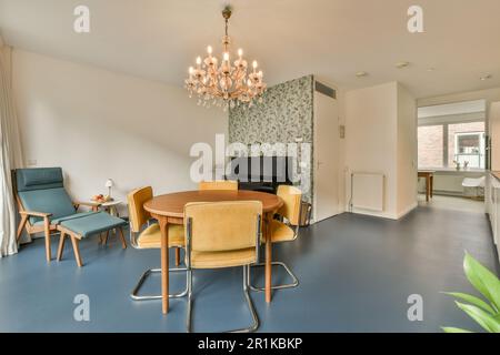 Ein Speisesaal mit blauem Fußboden und Tapeten an den Wänden, einschließlich einer großen Chandele Stockfoto