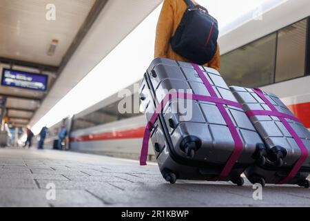 Nürnberg, Deutschland. 14. Mai 2023. Ein Reisender geht mit Koffern auf dem Bahnsteig am Nürnberger Hauptbahnhof neben einer EISBAHN. Der geplante 50-Stunden-Warnstreik bei der Deutschen Bahn wurde am Samstag (13. Mai) abgesagt. Die Deutsche Bahn und die Eisenbahn- und Verkehrsunion (EVG) hatten sich auf einen Vergleich beim Arbeitsgericht in Frankfurt am Main geeinigt. Kredit: Daniel Karmann/dpa/Alamy Live News Stockfoto