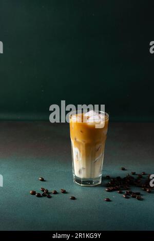 Schwarzer Kaffee mit Eis und Sahne in einem großen Glas. Kaffeebohnen. Stockfoto