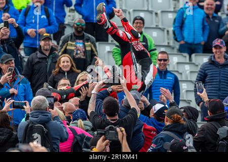 Portstewart, Großbritannien. 13. Mai 2023. Jubelnde Fans werfen Glenn Irwin nach seinem Sieg im Superbike-Rennen NorthWest200 in die Luft, bei dem es sich um Red Flag Credit: Bonzo/Alamy Live News handelte Stockfoto