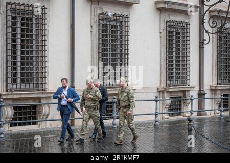 Rom, Italien. 13. Mai 2023. Zwei ukrainische Soldaten gehen anlässlich des Besuchs des ukrainischen Präsidenten Zelensky in Rom in Begleitung von zwei Vertretern der italienischen Behörden vor dem Palazzo Chigi auf der Piazza Colonna. Der ukrainische Präsident Wolodymyr Zelensky besucht Rom mehr als ein Jahr nach Beginn des Konflikts in der Ukraine. Nach der Landung in Ciampino traf er sich mit dem Staatsoberhaupt Sergio Mattarella, dem Ministerpräsidenten Giorgia Meloni und am Nachmittag Papst Franziskus. (Foto: Marcello Valeri/SOPA Images/Sipa USA) Guthaben: SIPA USA/Alamy Live News Stockfoto