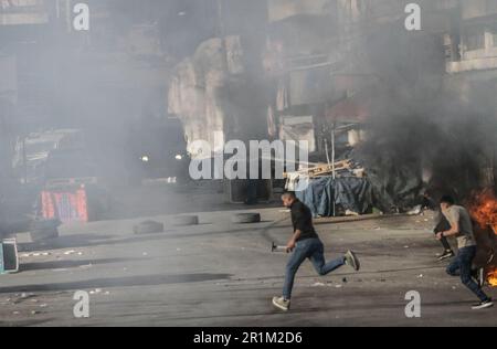 Nablus, Palästina. 14. Mai 2023. Palästinensische Jugendliche fliehen aus Tränengaskanistern, die von den israelischen Streitkräften während des Überfalls in der Stadt Nablus abgefeuert wurden, um einige gesuchte Personen von den israelischen Behörden östlich von Nablus im besetzten Westjordanland zu verhaften. (Foto von Nasser Ishtayeh/SOPA Images/Sipa USA) Guthaben: SIPA USA/Alamy Live News Stockfoto