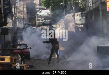 Nablus, Palästina. 14. Mai 2023. Palästinensische Jugendliche fliehen aus Tränengaskanistern, die von den israelischen Streitkräften während des Überfalls in der Stadt Nablus abgefeuert wurden, um einige gesuchte Personen von den israelischen Behörden östlich von Nablus im besetzten Westjordanland zu verhaften. (Foto von Nasser Ishtayeh/SOPA Images/Sipa USA) Guthaben: SIPA USA/Alamy Live News Stockfoto