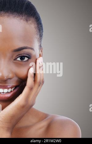 Schönheit kommt ihr ganz natürlich zu... Porträt einer wunderschönen afroamerikanischen Frau, die ihre Haut berührt. Stockfoto