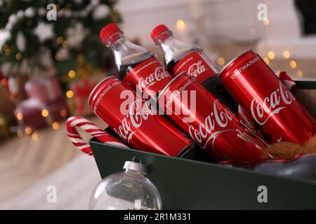 MYKOLAIV, UKRAINE - 13. JANUAR 2021: Coca-Cola-Flaschen und -Dosen im Karton, Nahaufnahme Stockfoto