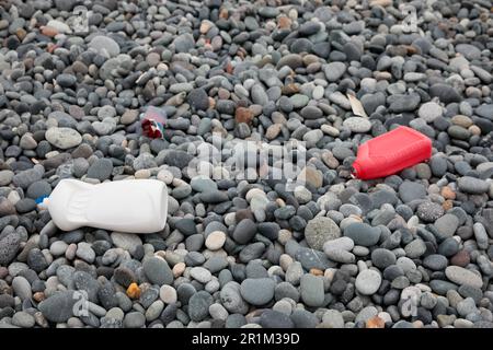 Plastikflaschen wurden an der Kieselküste weggeworfen Stockfoto