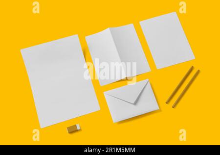 Weißes, leeres Schreibwarenmodell, Füge dein Design hinzu. Einfaches Back-to-School-Konzept, isoliert auf Gelb. Stockfoto