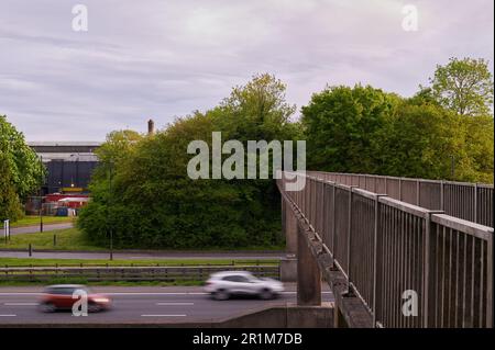 Fußgängerbrücke über die Autobahn mit Bewegungsunschärfe des sich bewegenden Verkehrs Stockfoto