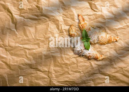 Frische hausgemachte Croissants auf Backpapier. Französisches Bäckereikonzept Stockfoto