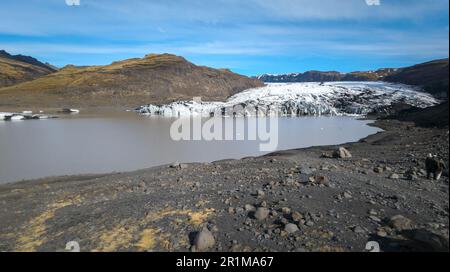 Eine malerische Szene eines ruhigen Sees mit mehreren großen, gebogenen und zerklüfteten Eisstücken, die im Wasser schweben Stockfoto